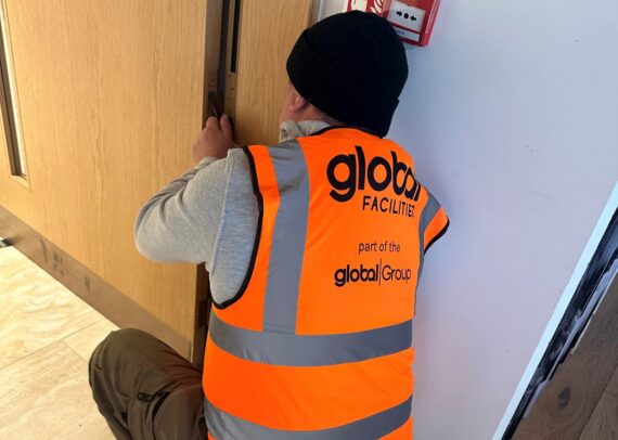 Global Facilities Inspector repairing a fire door