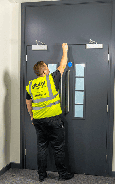 Worker checking fire door gap
